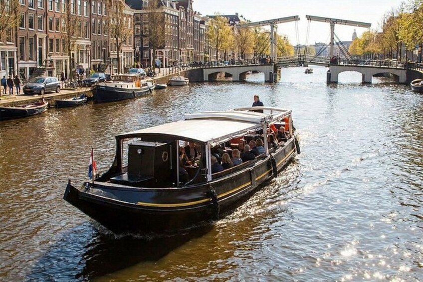 Un bateau transportant des passagers sur une rivière, entouré d’immeubles et d’un pont. 2
