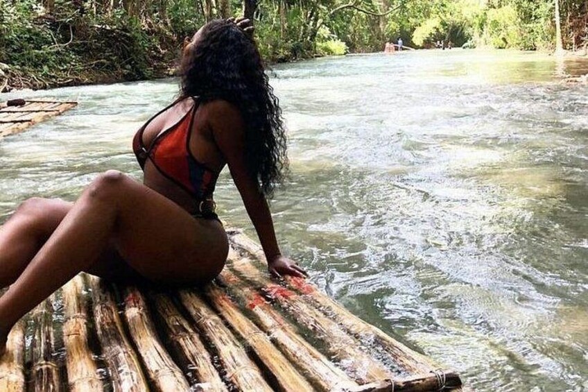 A person sitting on a wooden dock by a flowing river. 1