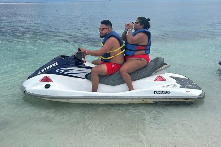 Two people on a Yamaha jet ski in clear water. 3