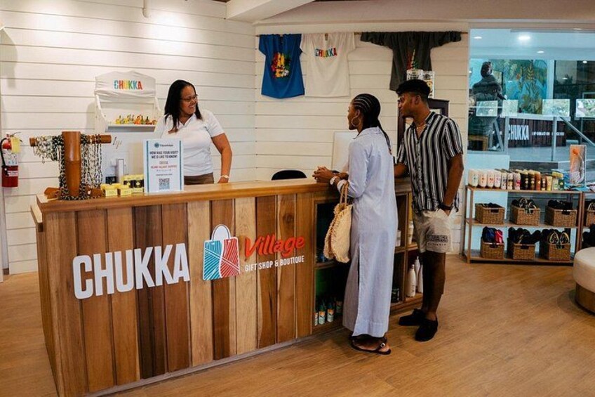 Een houten toonbank met het CHUKKA logo en een bordje voor de Village Gift Shop & Boutique. 3