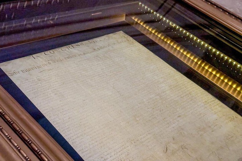 A historical document displayed in a glass case with a metal frame. 2