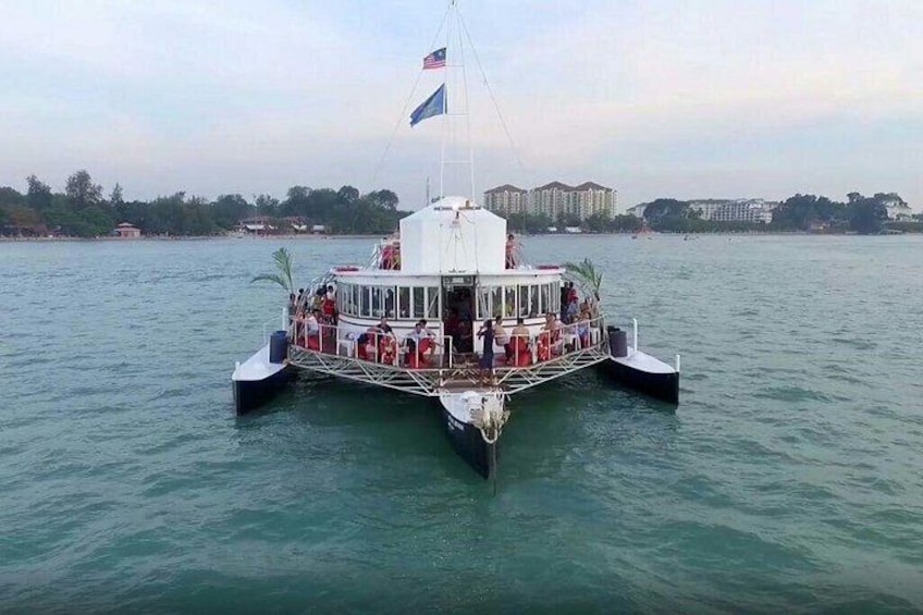 A ferry with multiple decks and passengers, docked at a pier with buildings in the background. 3