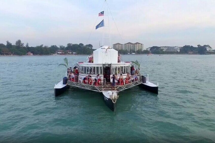 A ferry with multiple decks and passengers, docked at a waterfront with buildings in the background. 3