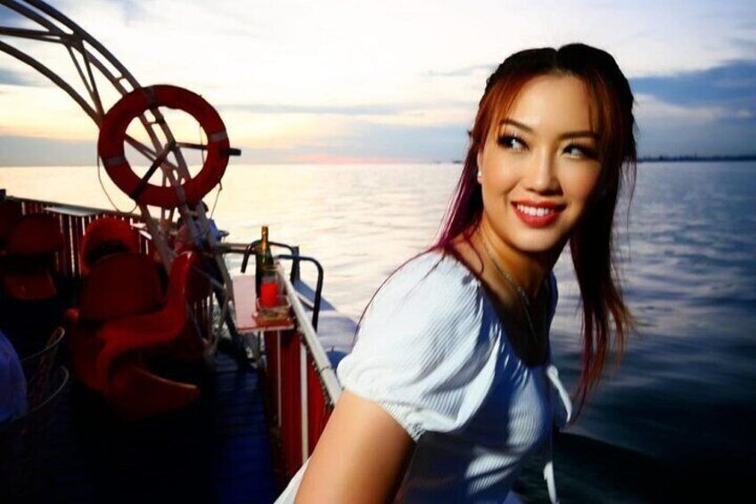 A person on a boat with a lifebuoy and steering wheel visible. 2
