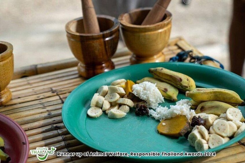 A green plate with sliced bananas, coconut, and spices on a bamboo mat. 4