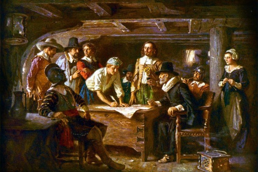 A group of people in a dimly lit room, some reading a map, others engaged in conversation, with a wooden table and a chair in the foreground. 3