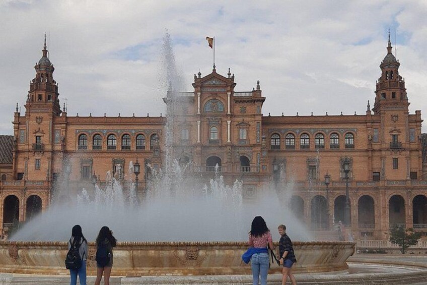 A historic building with a large fountain in front. 1