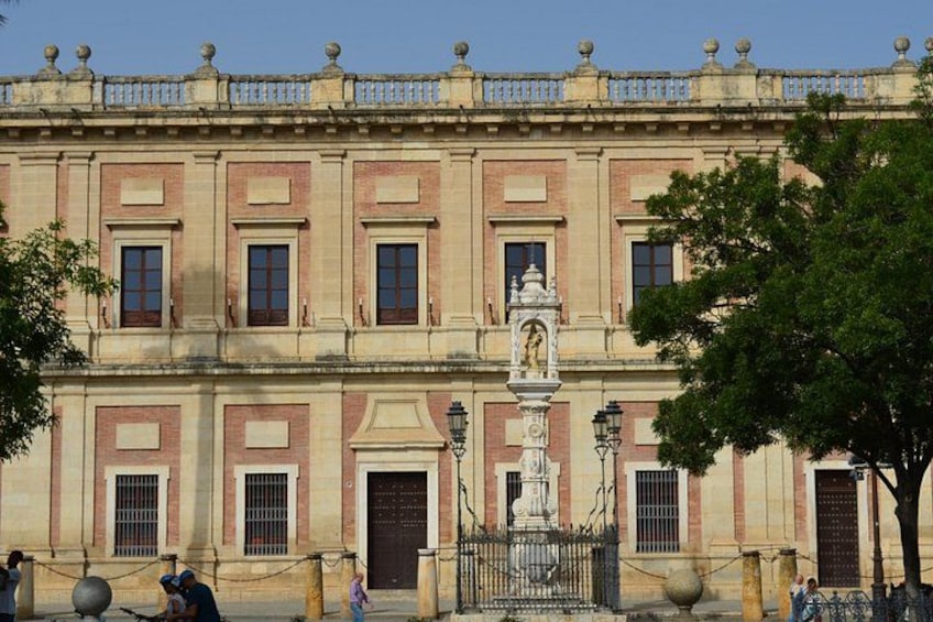 A historic building with a symmetrical facade, large windows, and a central statue. 2