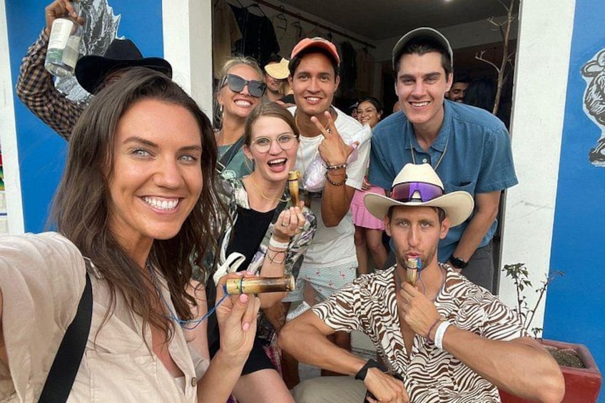 A group of people holding drinks, with a blue wall and a door in the background. 5