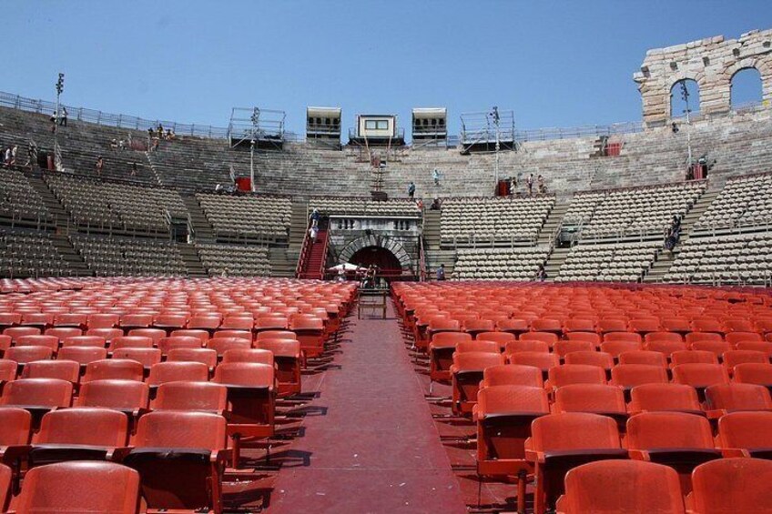 Un amphithéâtre antique avec des sièges rouges et des structures en pierre. 4