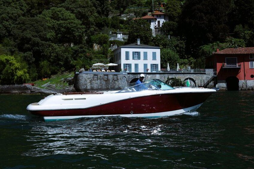 Een speedboot op het water, met een huis en bomen op de achtergrond. 3