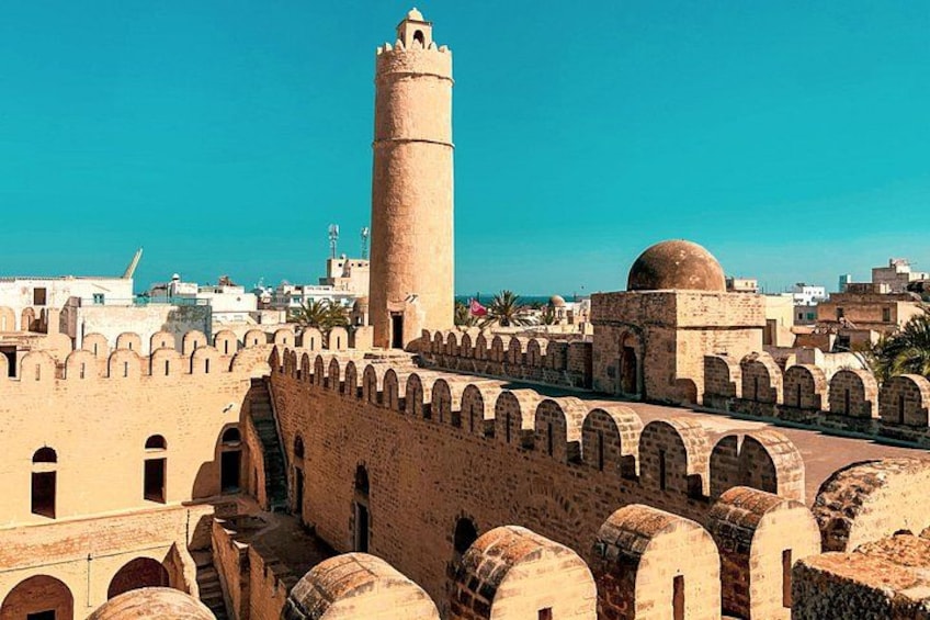 A historic city wall with arches, a prominent tower, and a dome structure. 3