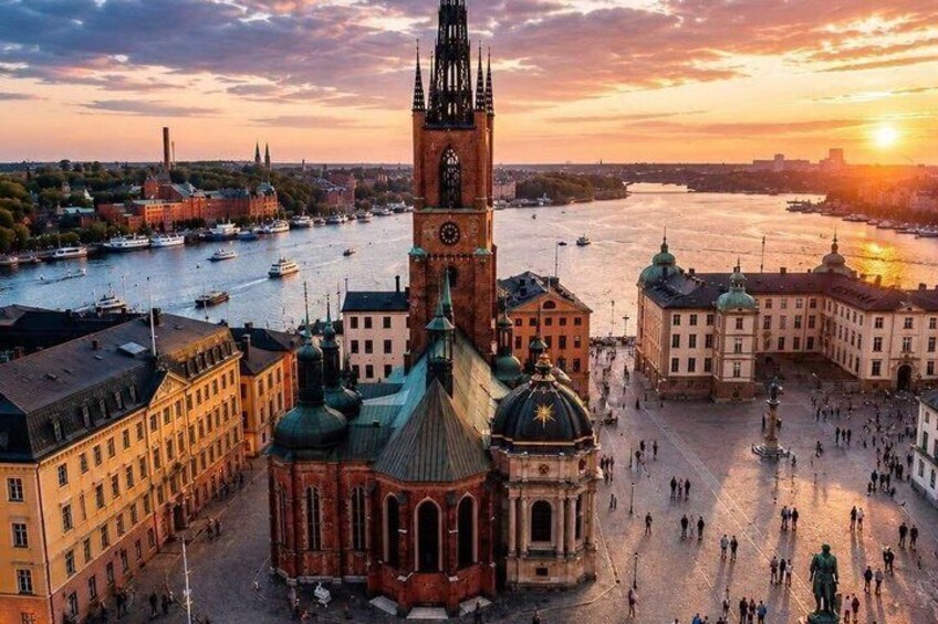 Eine Stadtansicht mit einem markanten Kirchturm, einem Fluss und einem Sonnenuntergang. 3