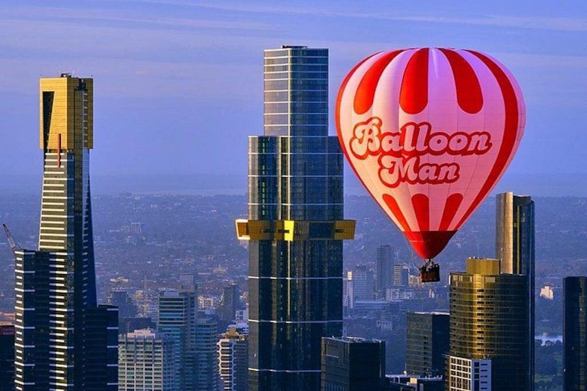 A cityscape with modern skyscrapers and a hot air balloon with 'Balloon Man' written on it. 1