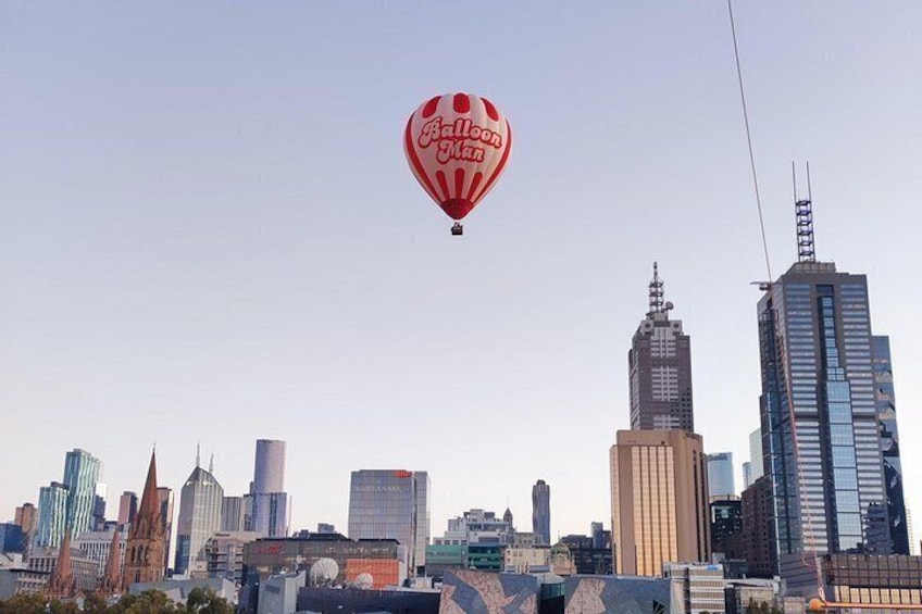 A city skyline with modern buildings and a hot air balloon in the sky. 2