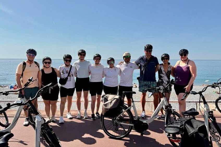 A group of people with bicycles on a beach. 3