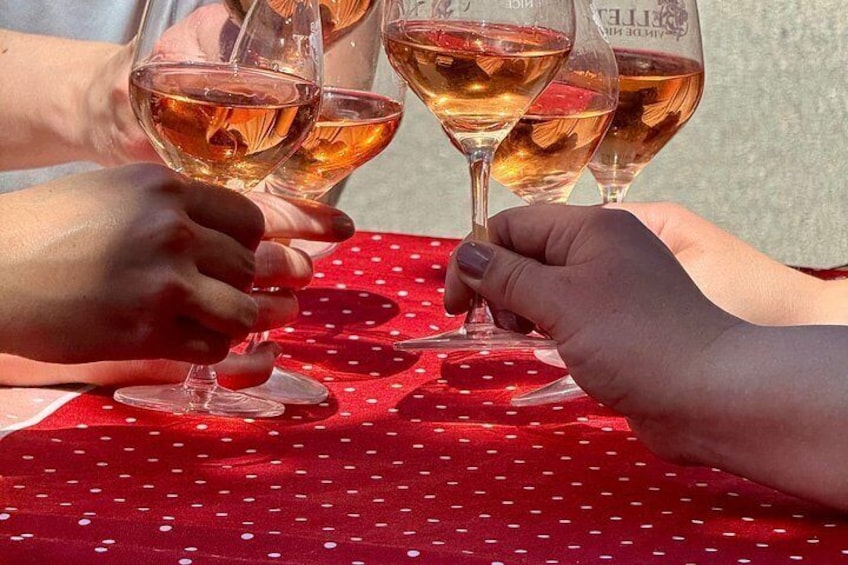 A person holding a wine glass at a table with a red tablecloth. 5