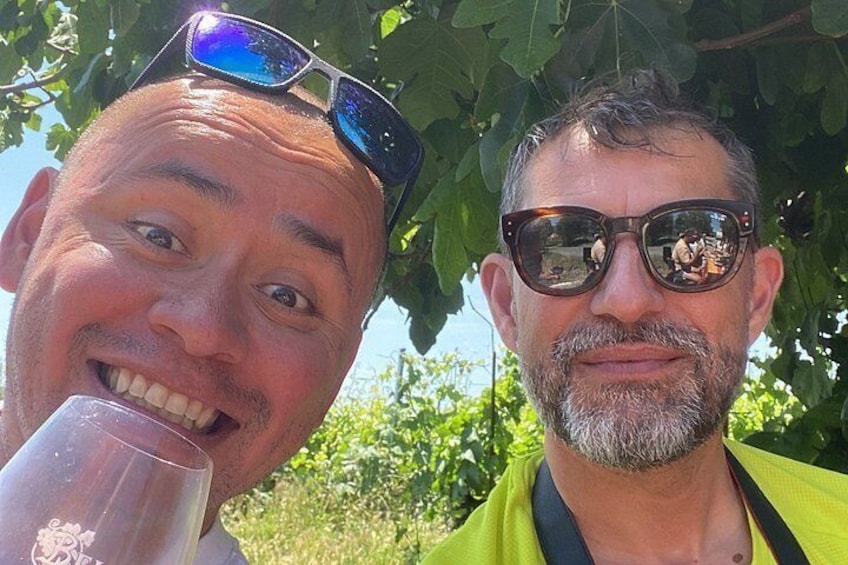 Two individuals outdoors, one holding a glass. 2
