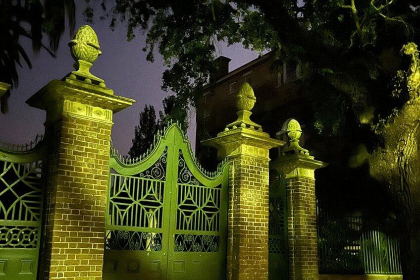 A gated entrance with ornate metalwork and brick pillars. 2
