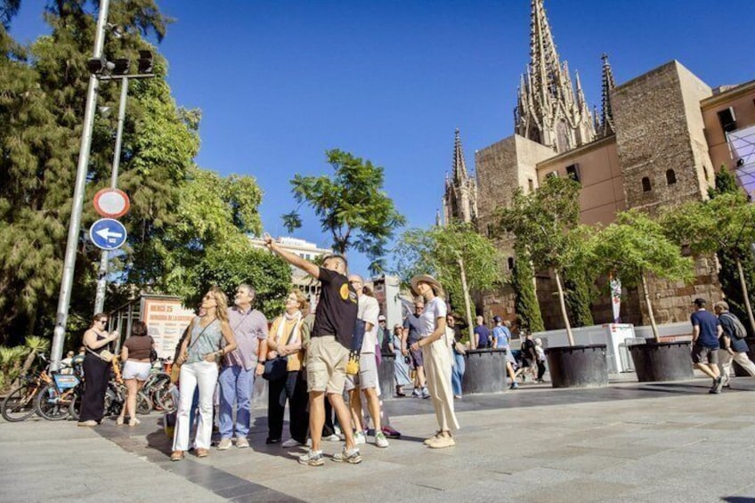 A group of people standing on a city square with a historic building in the background. 1