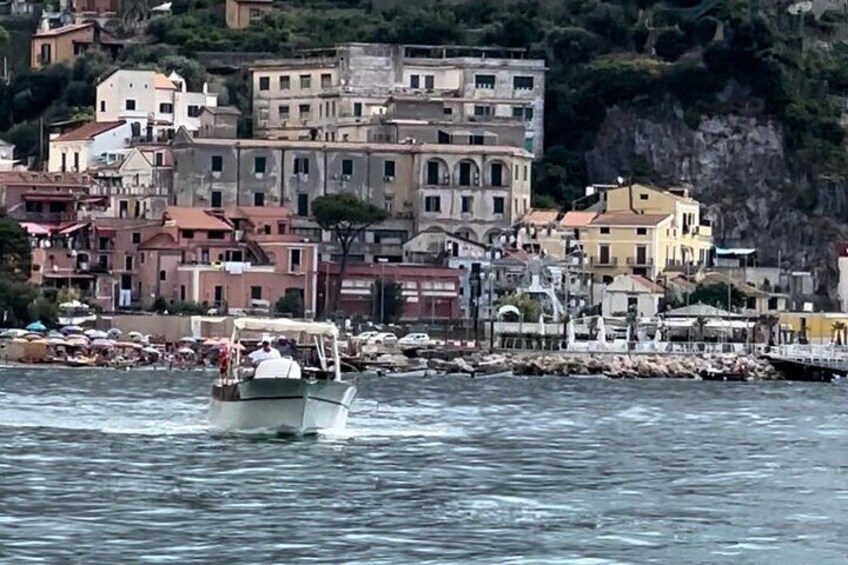 Un barco navegando por un puerto con edificios al fondo. 2