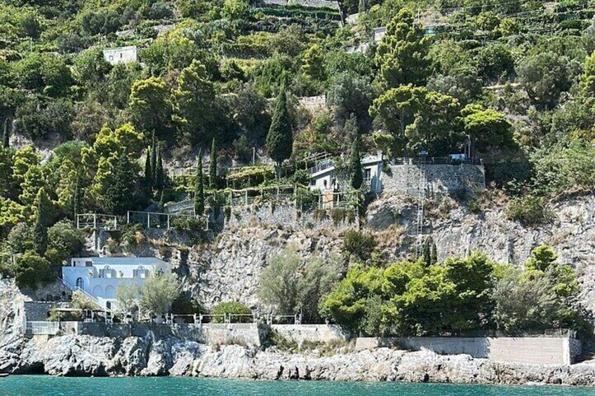 Un pueblo costero con edificios en una ladera rocosa, con vistas al mar. 3