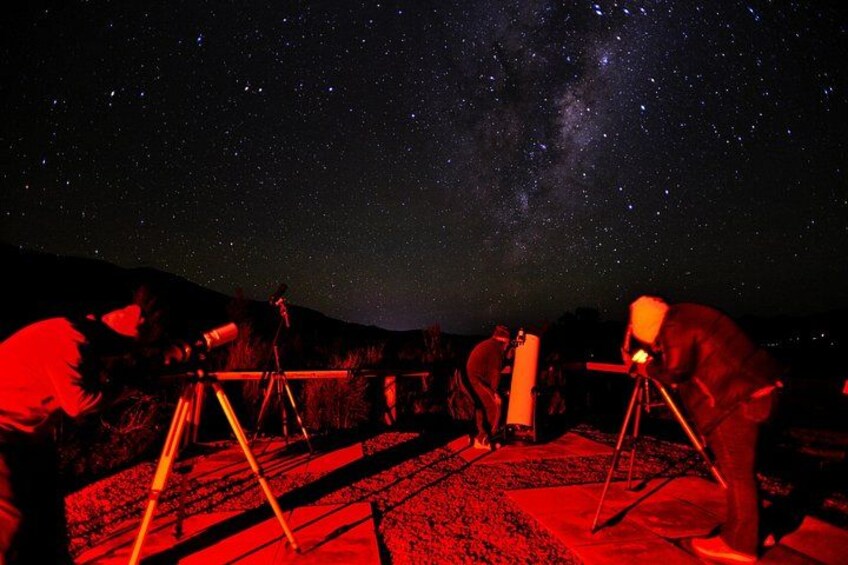 A group of people observing the night sky with telescopes. 5