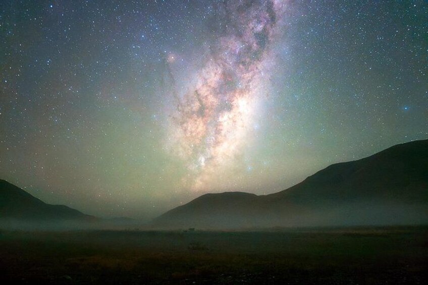 A starry night sky with the Milky Way visible, a mountainous landscape, and a foggy foreground. 3