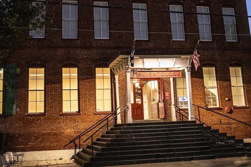 A brick building with a sign reading 'SCIENCE' at the entrance, steps leading up to the door, and an American flag above. 2