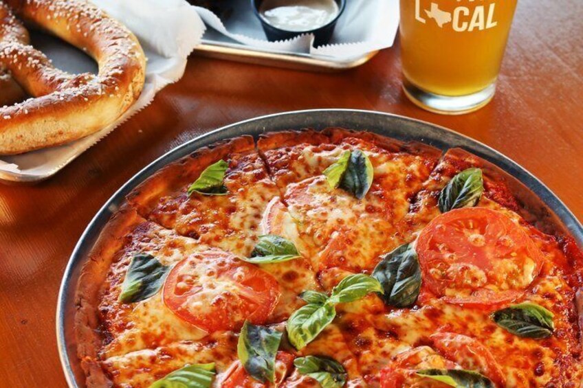A pizza with tomatoes and basil on a tray. 3