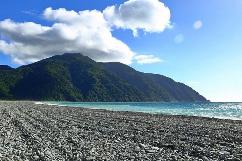 A pebble beach with a mountain in the background. 3