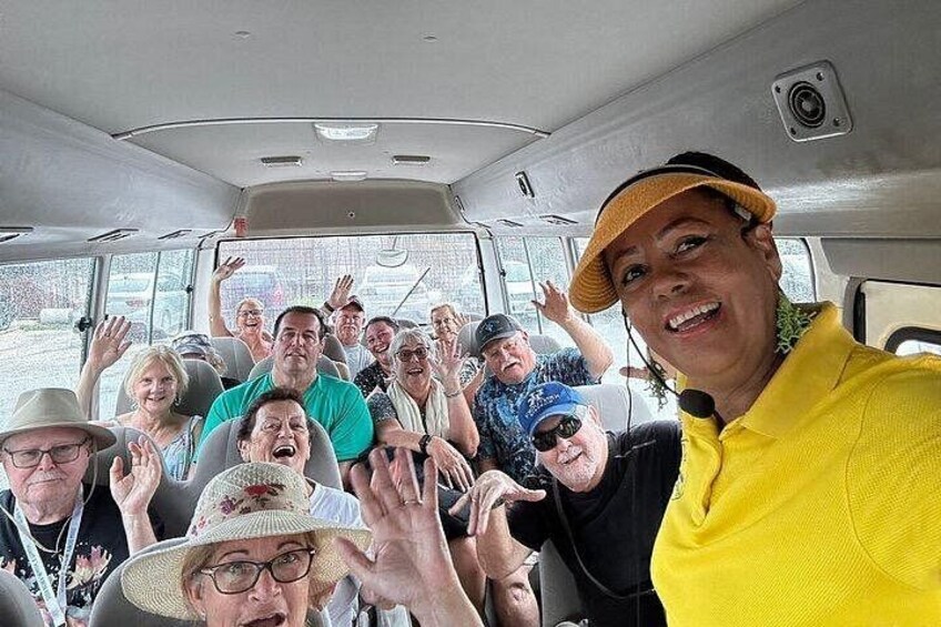 A group of people inside a vehicle, some raising their hands. 3