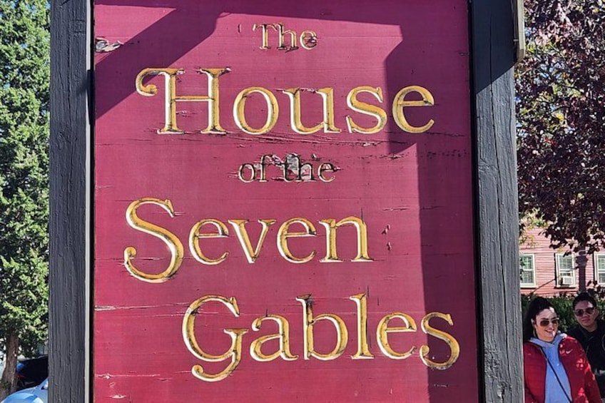 A red sign with gold lettering that reads 'The House of the Seven Gables.' 3