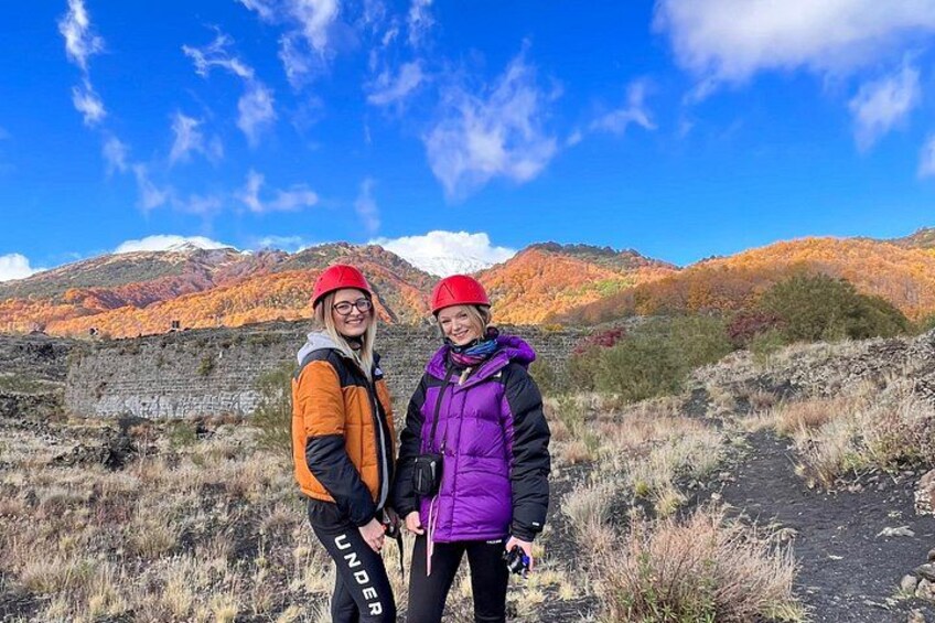 Two people standing on a rocky path with mountains in the background. 2