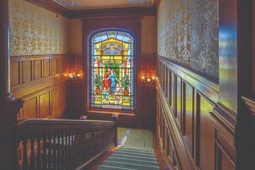 A grand staircase leading to a stained glass window with intricate designs. 4