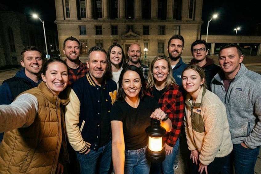 Un grupo de personas tomándose un selfie frente a un edificio de noche. 2