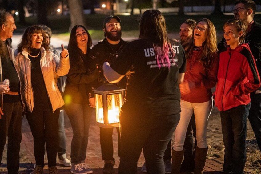 A group of people gathered around a lantern. 2