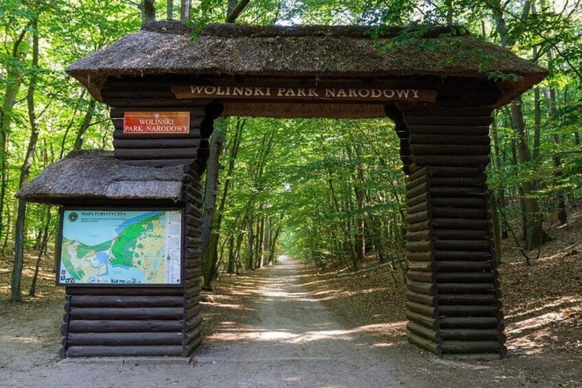A wooden archway with a map and signs at WOLINSKI PARK NARODOWY. 1