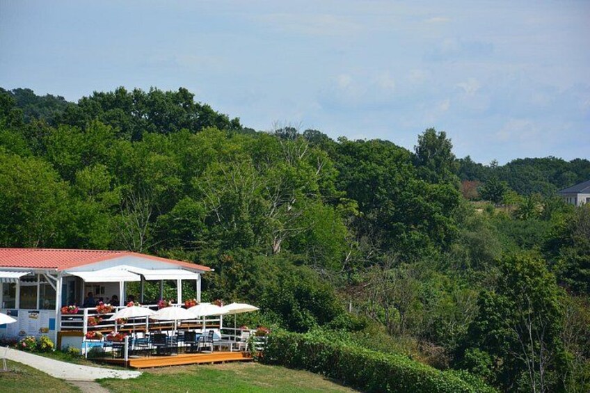A gazebo with outdoor seating, surrounded by lush greenery and a hill in the background. 4