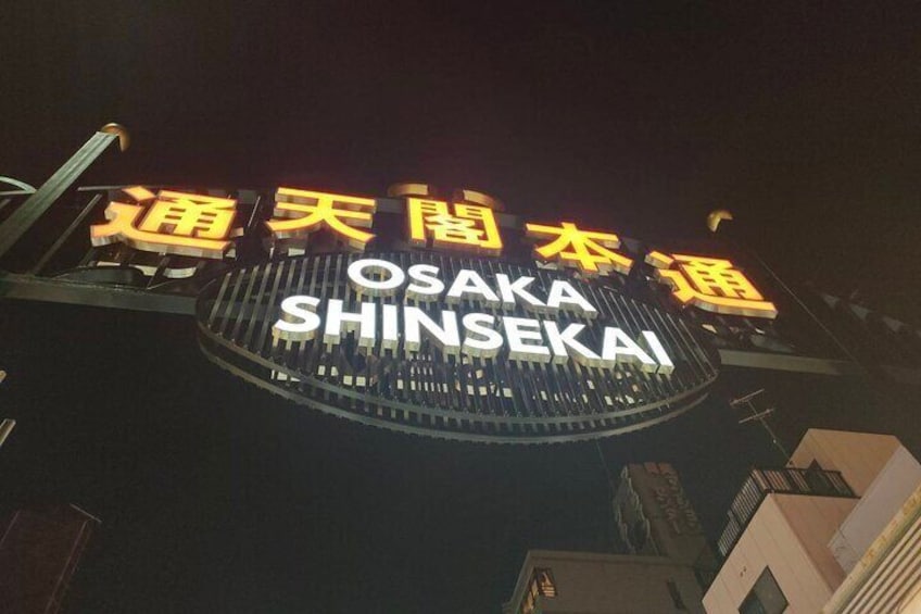Un cartel con el nombre 'Osaka Shinsekai' en inglés y otro idioma. 4