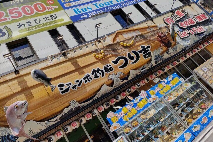 Un mercado de mariscos con un amplio letrero de madera y diversas exhibiciones de productos del mar. 5