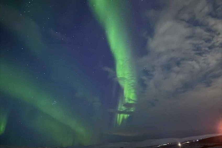 La aurora boreal (Luces del Norte) con una luz verde visible y un cielo oscuro. 4