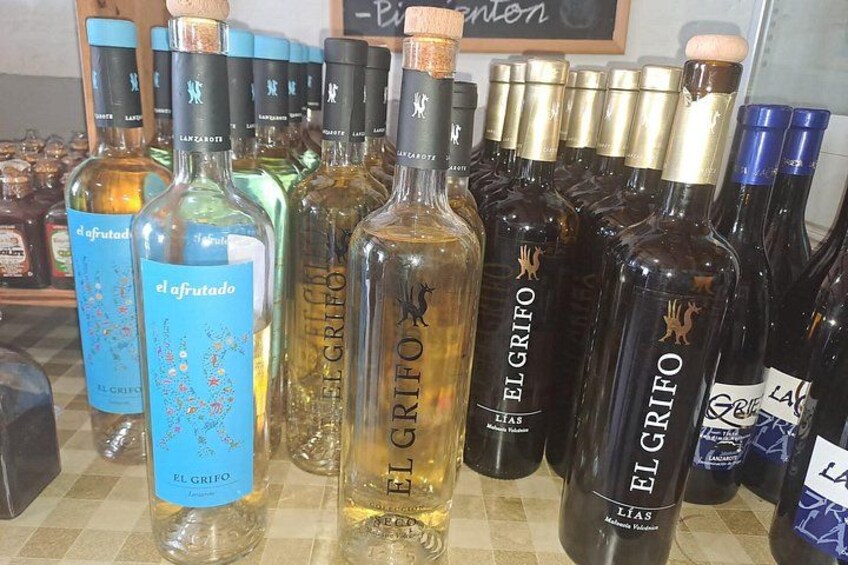 A variety of alcohol bottles, including brands like 'el grifo' and 'afrutado,' arranged on a shelf. 2