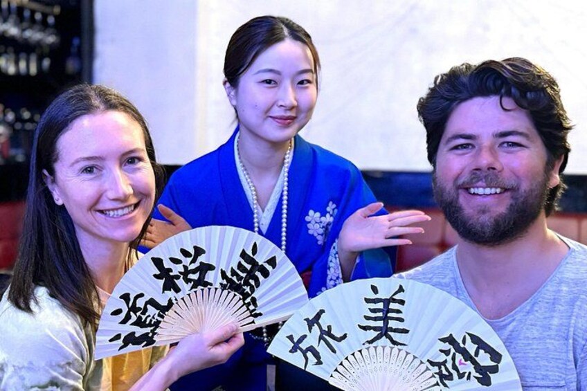 Three people holding fans with Japanese calligraphy. 4