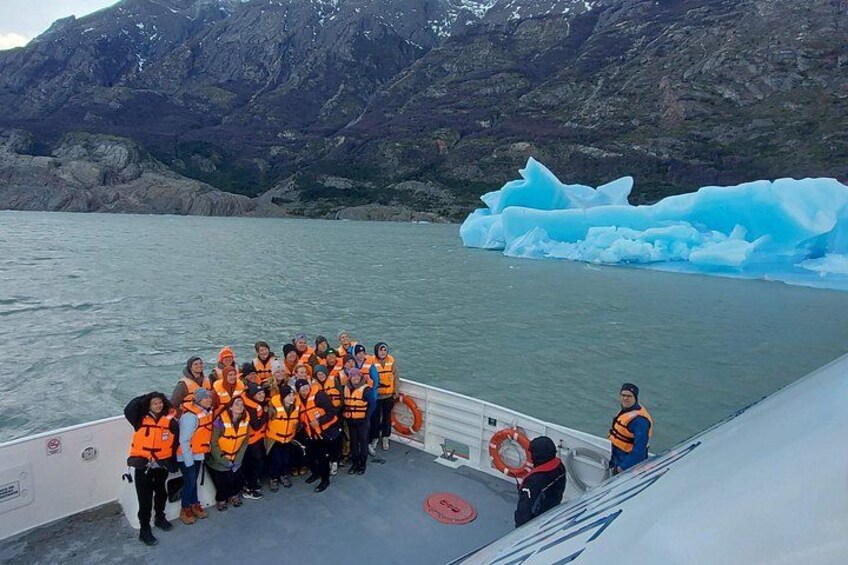 A group of people on a boat near a glacier. 2