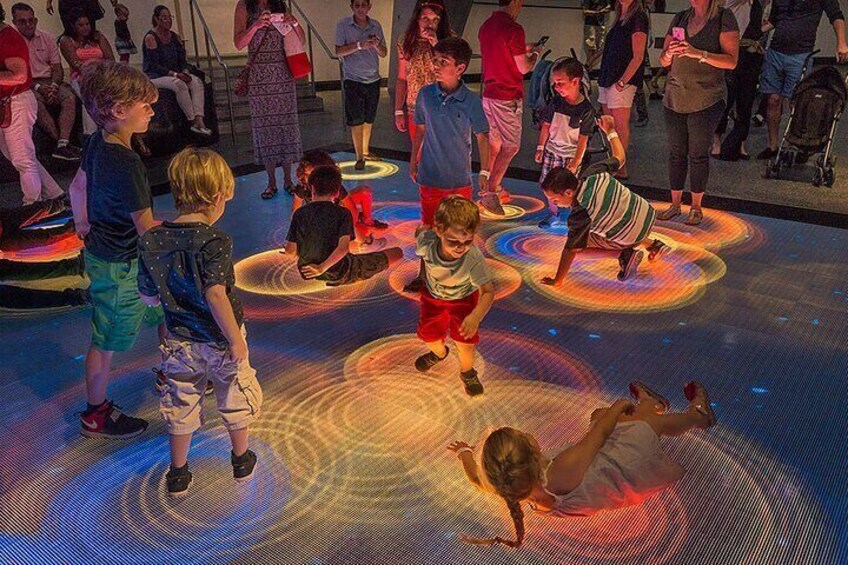 Kinderen spelen op een vloer met interactieve lichteffecten. 5