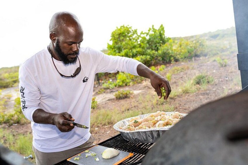 A person grilling food outdoors with a grill and vegetables visible. 4