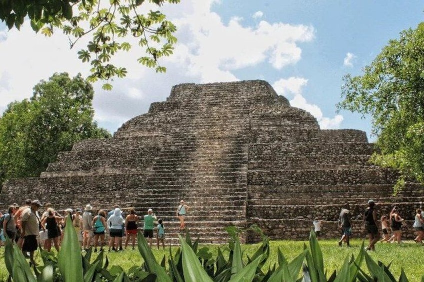 Una gran estructura de piedra antigua rodeada de visitantes. 2
