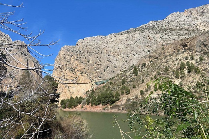 Un paisaje montañoso con un río, acantilados rocosos y vegetación escasa. 4