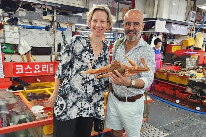 Dos personas en un mercado sosteniendo mariscos. 3